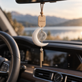 Pale crescent motif with a grey stone-look disc and slim gold-tone hanging tubes